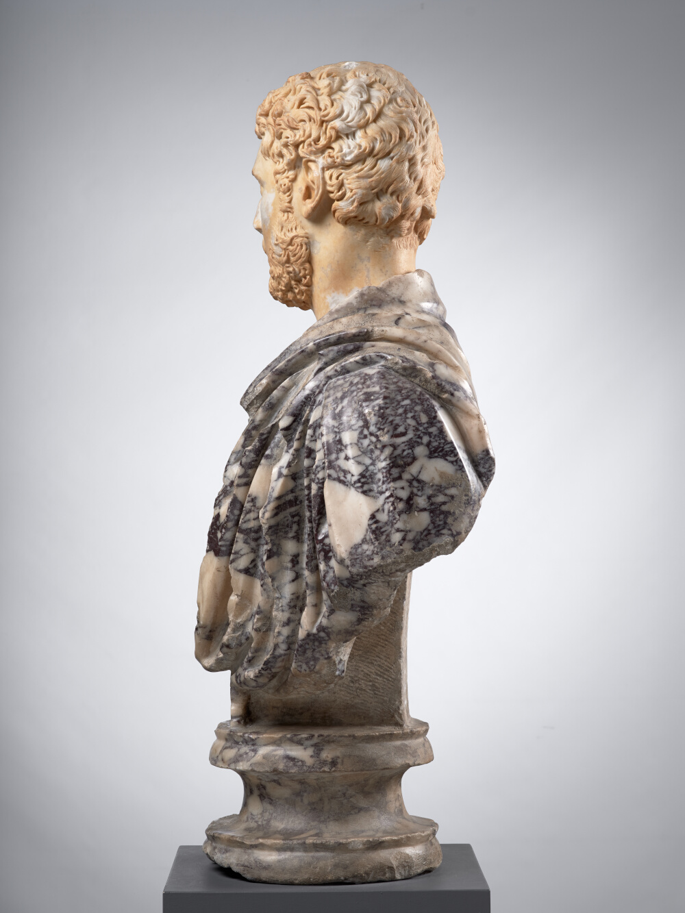 Man’s head, now mounted on a bust of Pavonazzetto marble